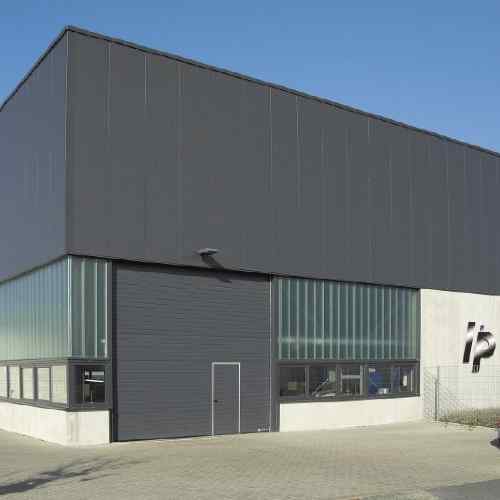 Großes Hörmann Industrie-Sektionaltor anthrazit an moderner Produktionshalle