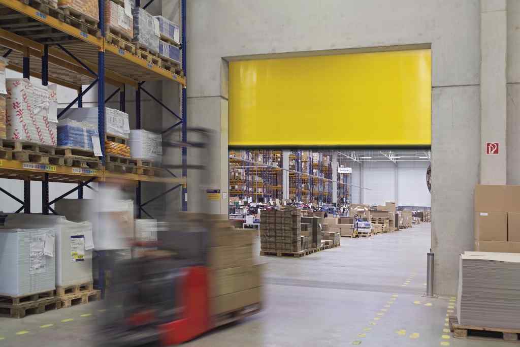 Hörmann Schnelllauftor gelb V 4015 — Gabelstapler durchfährt geöffnetes Innentor in Lagerhalle