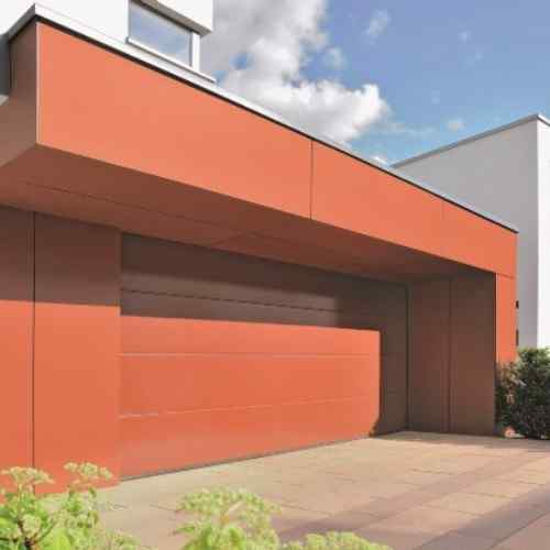 Modernes terrakottafarbenes Wohnhaus mit flächenbündig integriertem Hörmann Sektionaltor