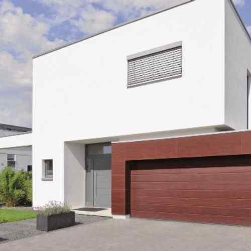 Weißes Einfamilienhaus mit Hörmann Sektionaltor DuoGrain Holzdekor dunkelbraun
